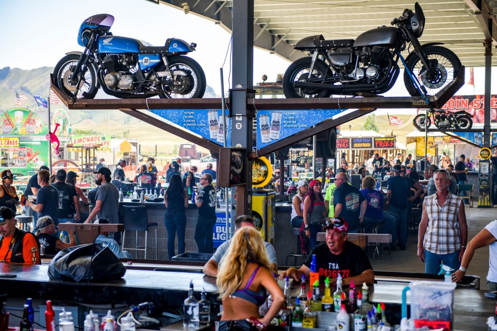 People sit at the outdoor bar of the Full Thottle Saloon during the 80th Annual Sturgis Motorcycle Rally.