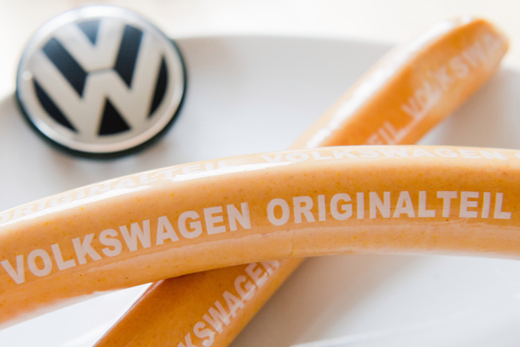 Curry sausages with 'Volkswagen Originalteil' lying on a kitchen table.