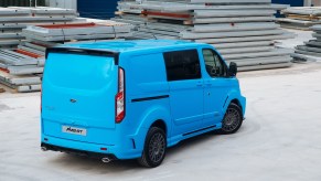 a bright blue Ford Transit connect cargo van working as an urban work truck
