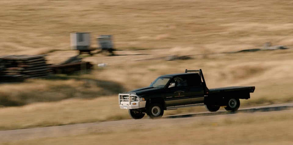 old ram ranch truck at speed on a dirt ranch road