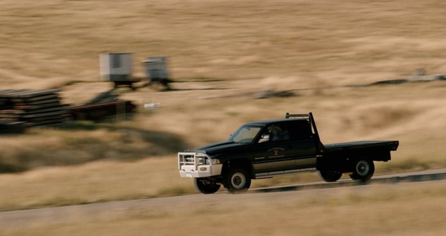 old ram ranch truck at speed on a dirt ranch road
