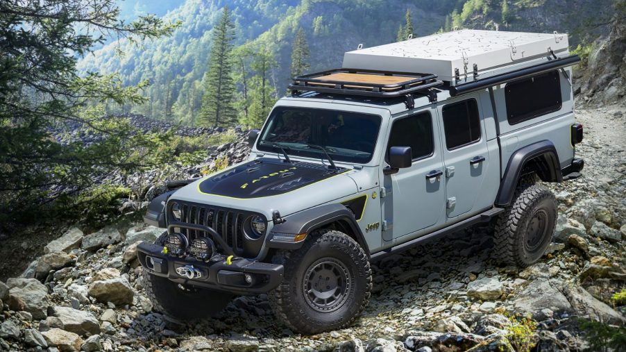 A gray Jeep Gladiator pickup is going down a trail road.