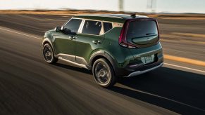 a green Kia Soul at speed on the highway