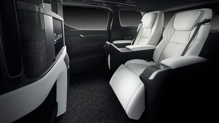 executive recliner seats in white leather in front of an impressive touch screen display