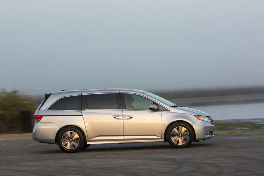 a silver Honda Odyssey driving near the shore. It's a great choice for a used minivan