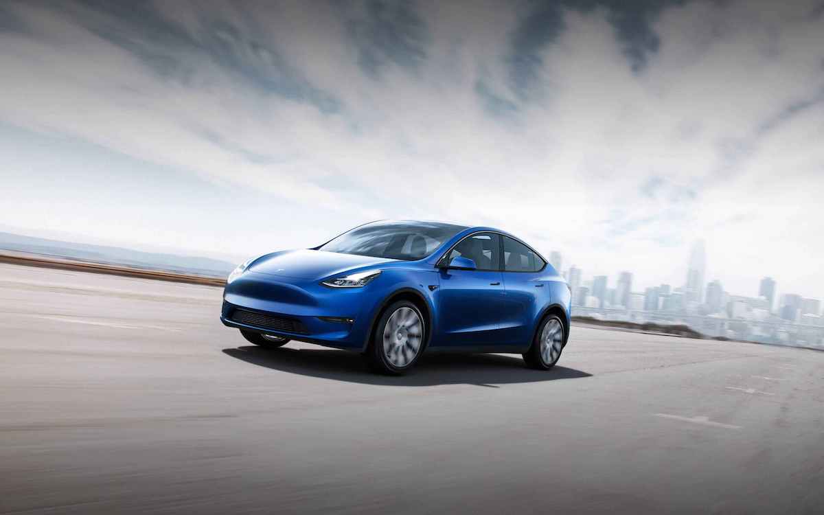An image of a blue Tesla Model Y driving down the road.