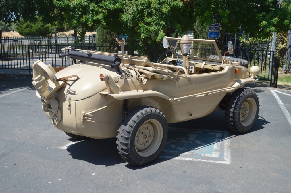 The rear-3/4 view of a tan 1944 Volkswagen Type 166 Schwimmwagen with its propeller up