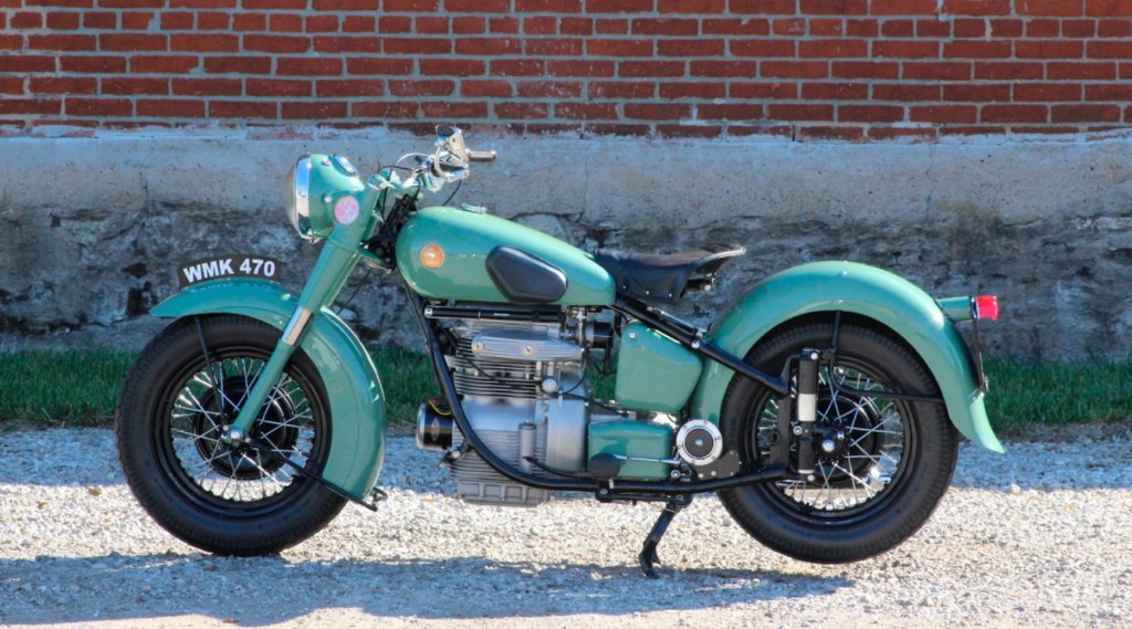 A turquoise 1951 Sunbeam S7 Deluxe in front of a brick wall