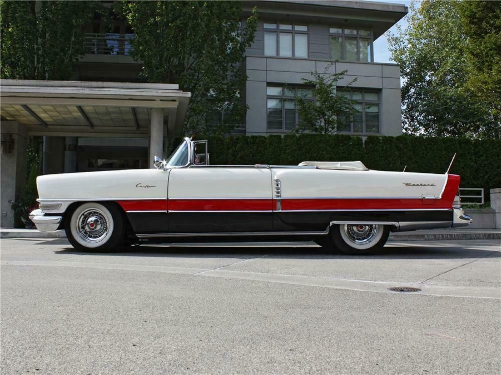 The side view of a white-red-and-black 1955 Packard Caribbean convertible