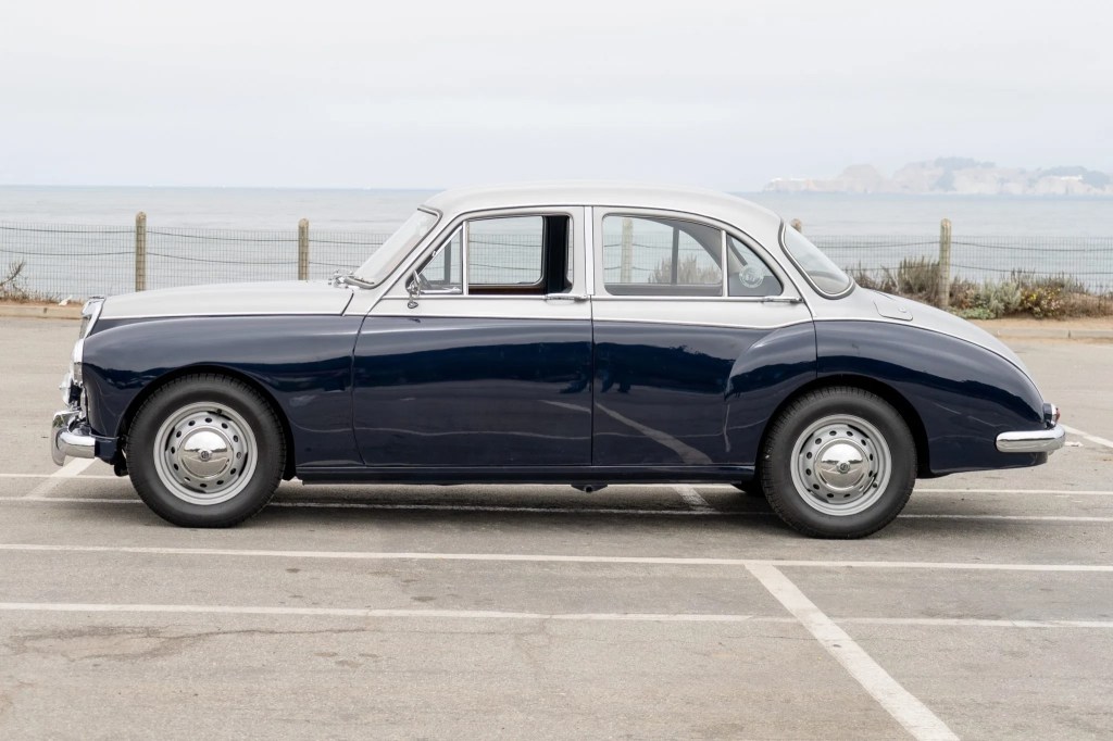 The side view of a blue-and-silver 1958 MG Magnette ZB Varitone by the sea