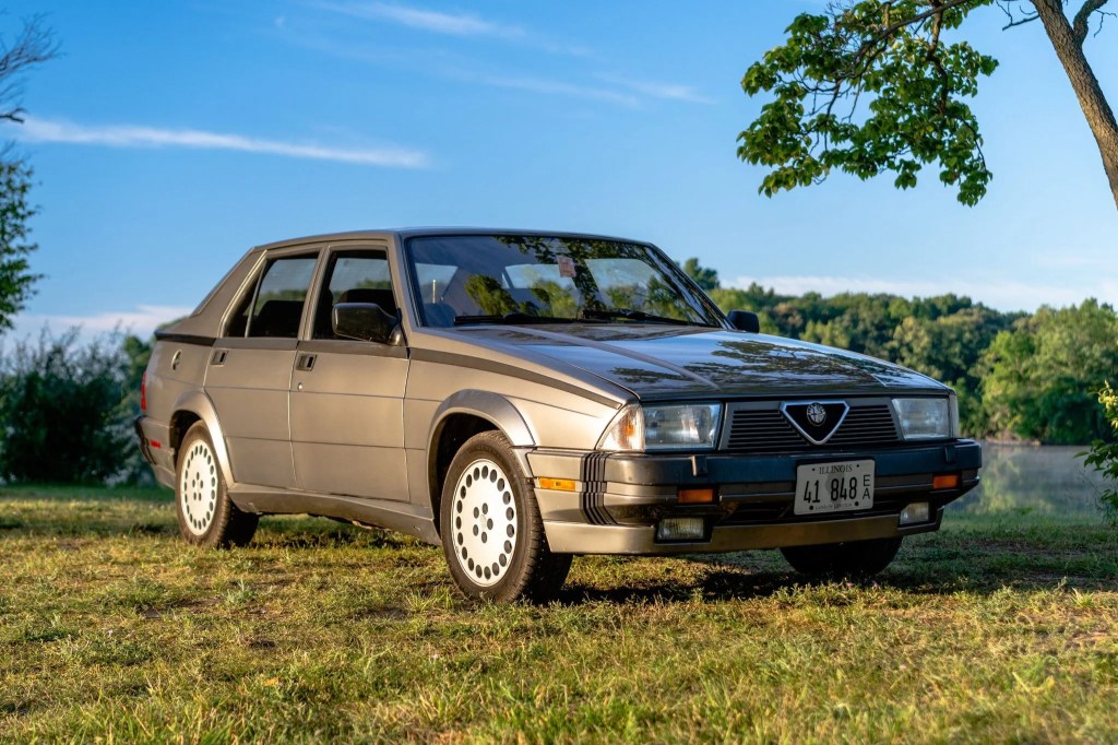 A gray 1988 Alfa Romeo Milano Verde lit by the setting sun