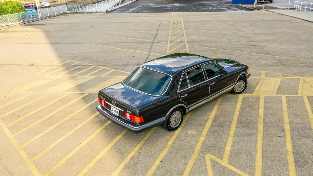 An overhead rear 3/4 view of a black 1991 W126 Mercedes-Benz 560SEL in a parking lot
