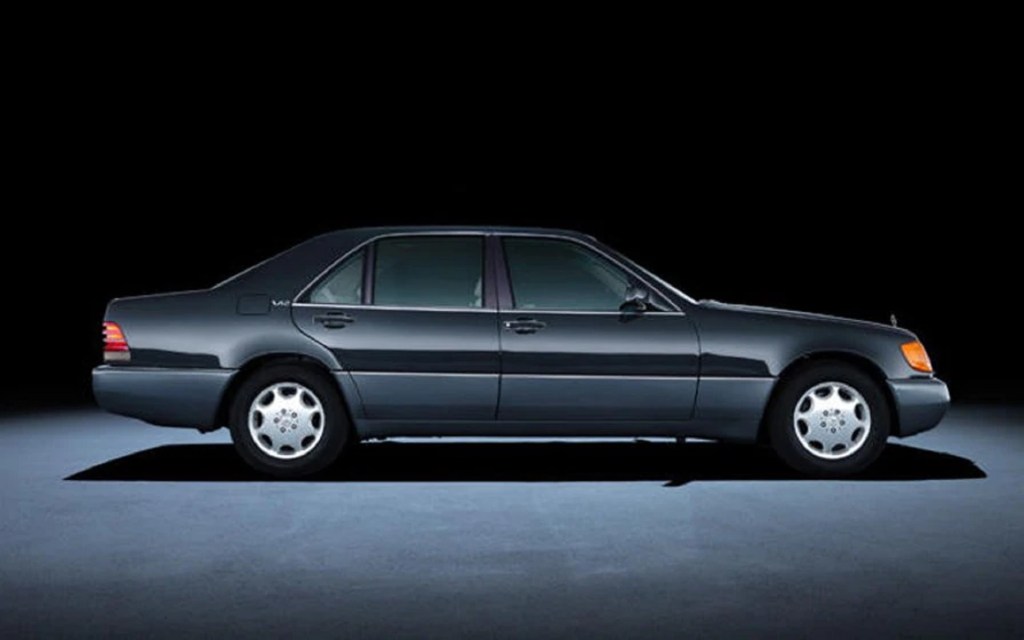 The side view of a black V12-powered 1992 Mercedes-Benz W140 S-Class sedan far more luxurious than a Toyota Camry