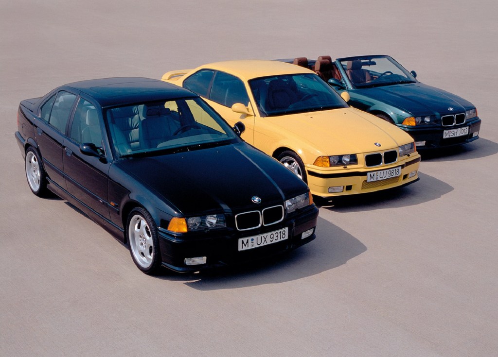 A black 1995 BMW E36 M3 sedan next to a yellow coupe next to a green convertible