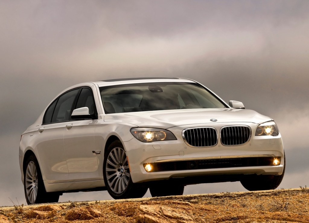 A white 2011 BMW 750Li on top of a rocky rise