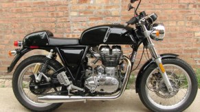 A black 2014 Royal Enfield Continental GT 535 against a brick wall