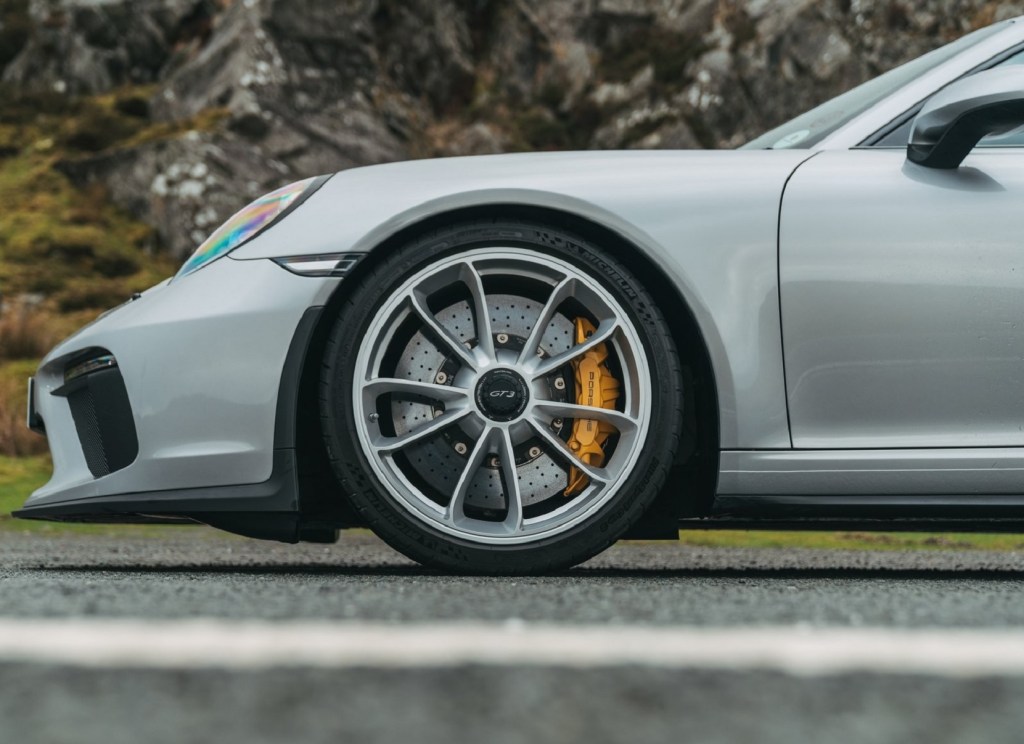 A silver 2018 Porsche 911 GT3 and its drilled brake rotors with yellow calipers
