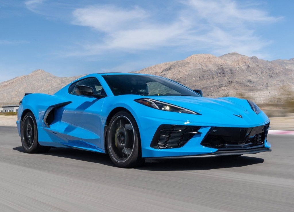 A blue 2020 Chevrolet Corvette C8 Stingray races around a desert racetrack, exemplifying the reasons for its MotorTrend car of the year award