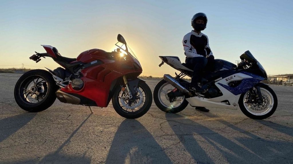 A red 2020 Ducati Panigale V4 S next to a white-and-blue 2005 Suzuki GSX-R1000 in front of the setting sun