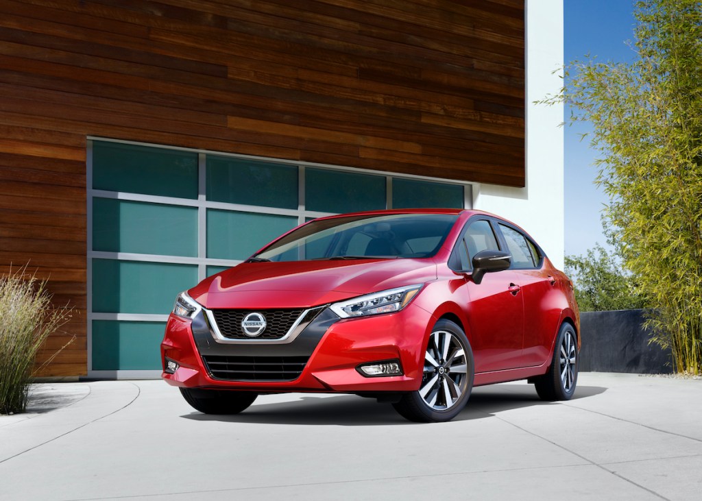 2020 Nissan Versa parked outside of a glass panel garage