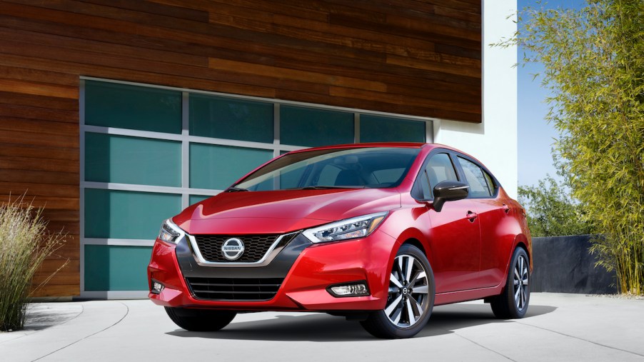 2020 Nissan Versa parked outside of a glass panel garage