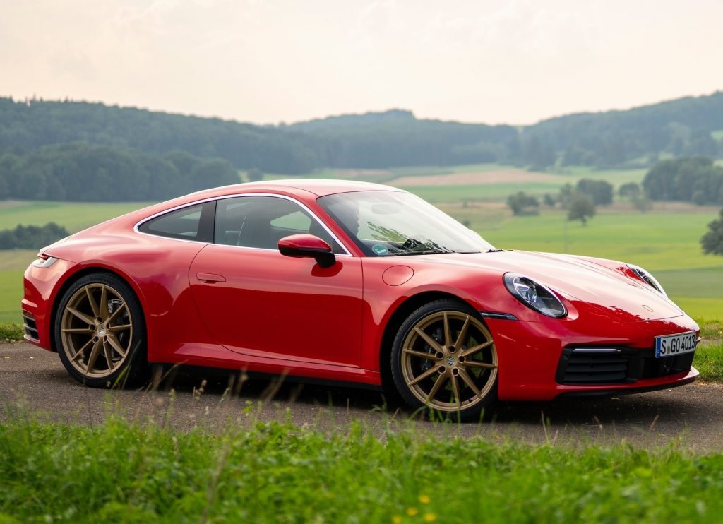 A red 2020 Porsche 911 Carrera amongst rolling green hills