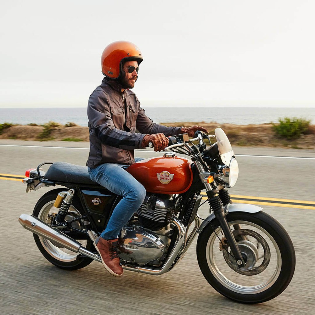 An orange-helmeted rider on an orange 2020 Royal Enfield Interceptor 650