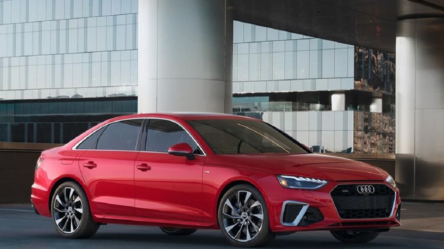A red 2021 Audi A4 in front of a modern building