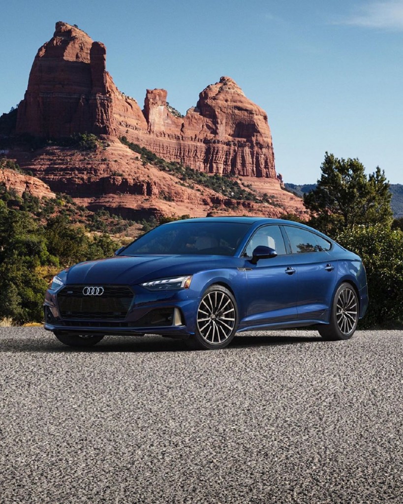 A blue 2021 Audi A5 Sportback in front of a desert rock formation