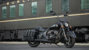 A black 2021 Indian Vintage Dark Horse with optional tall handlebars in front of a train