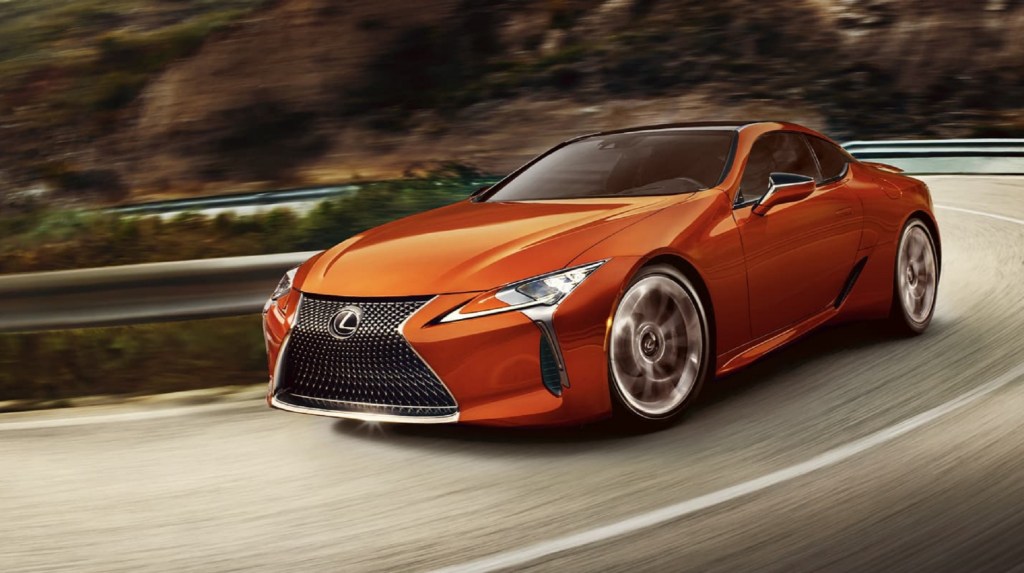 2021 lexus LC 500h in a gorgeous orange carving corners on a mountain road