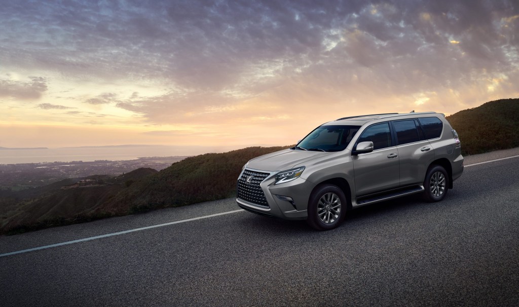 a silver 2021 Lexus GX 460 model on a lovely road with a beautiful harbor in the background