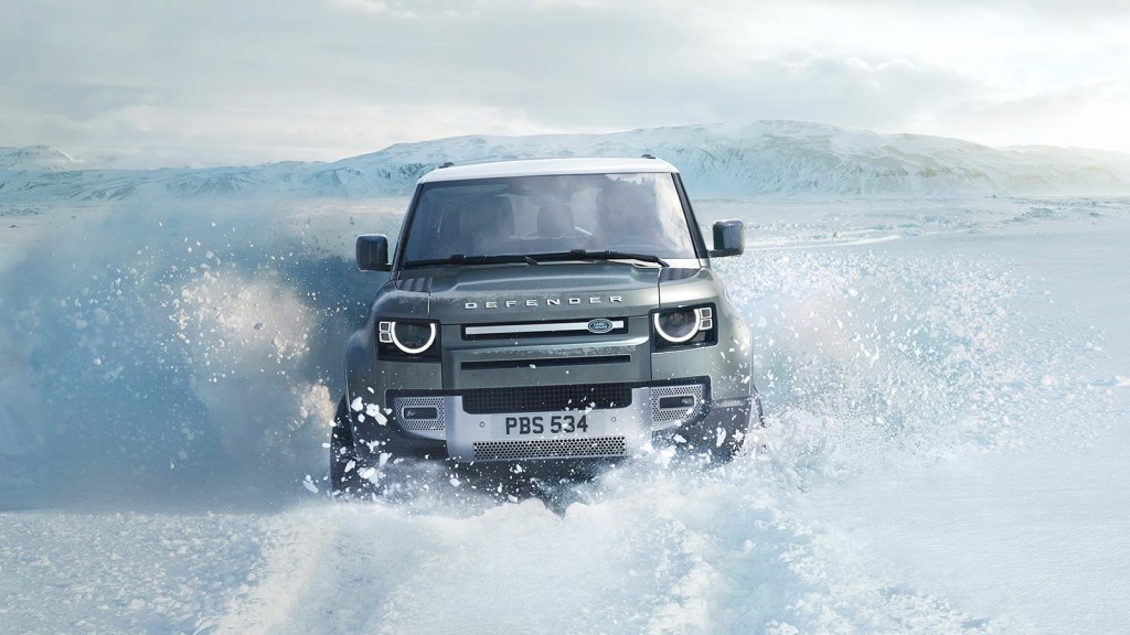 A 2021 Land Rover Defender wading through water.