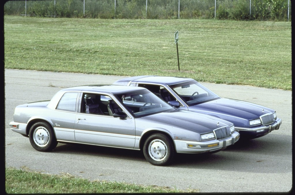 Gray 1988 Buick Rivera model parked next to a dark blue 1989 Buick Rivera model which is 11 inches longer.