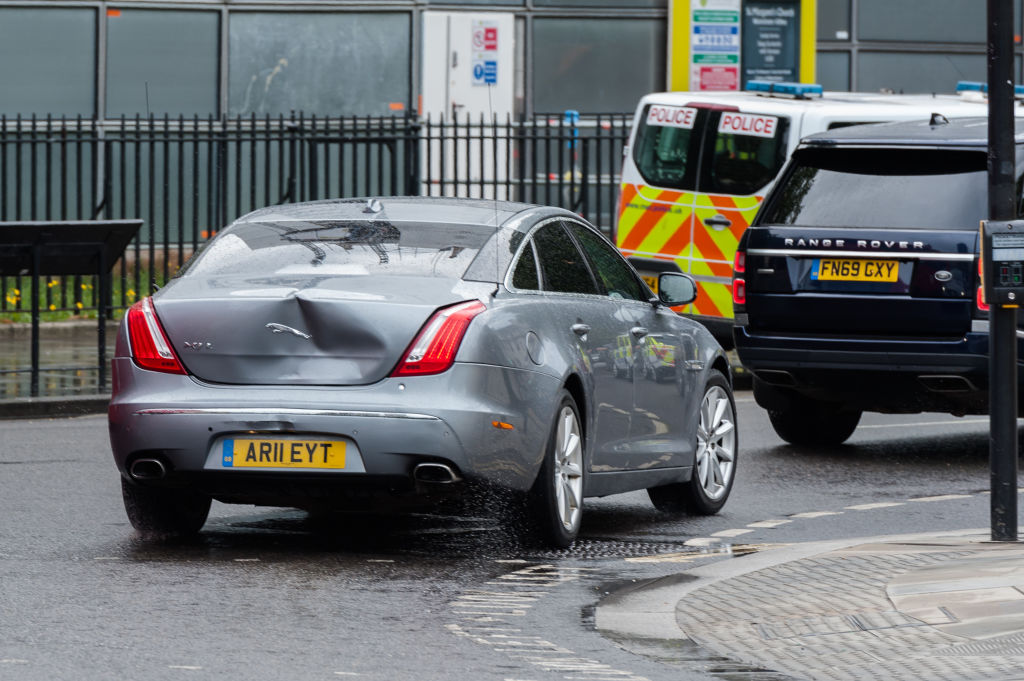 a jaguar with rear fender bender damage on a city street in Britain