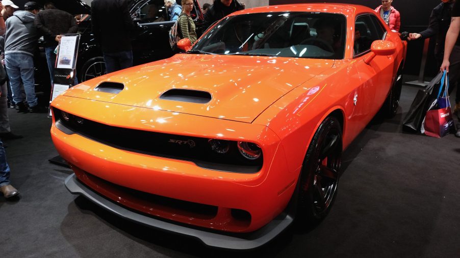An orange Dodge Charger on display at an auto show