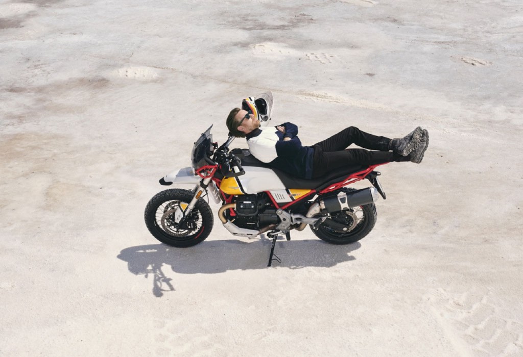 Ewan McGregor sitting on a white-and-yellow Moto Guzzi V85TT Adventure