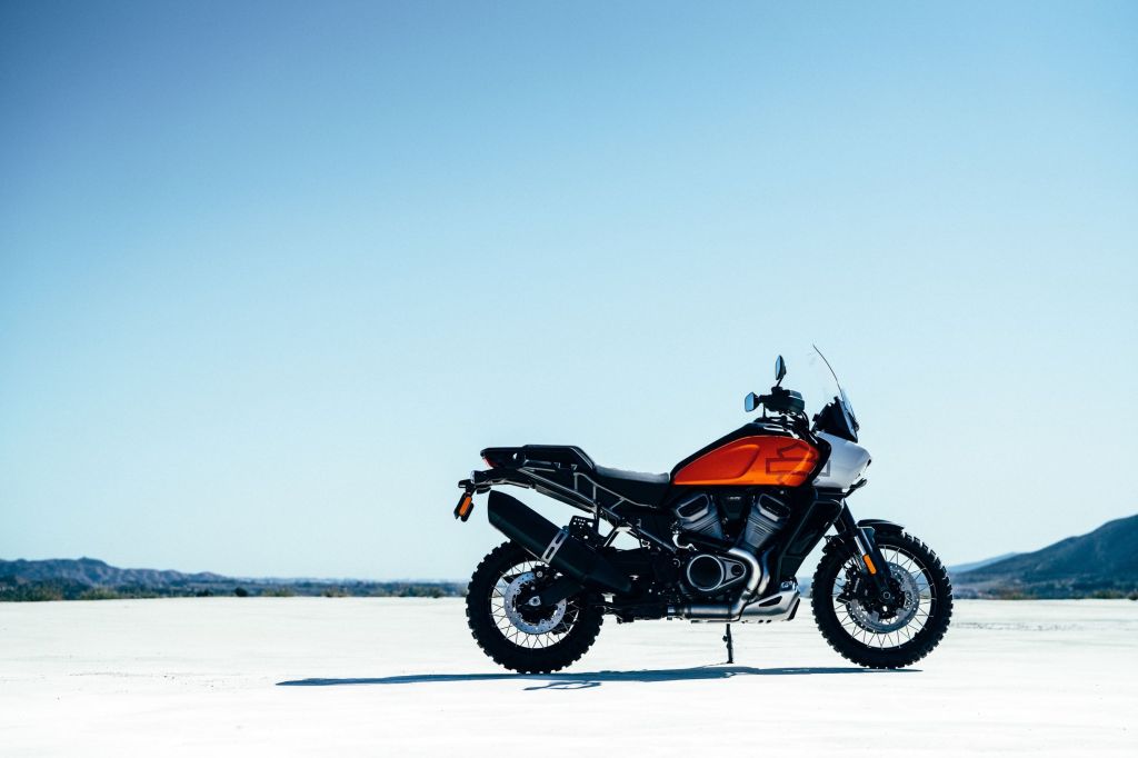 An orange-tanked Harley-Davidson Pan America concept parked on a dry lakebed