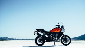 An orange-tanked Harley-Davidson Pan America concept parked on a dry lakebed