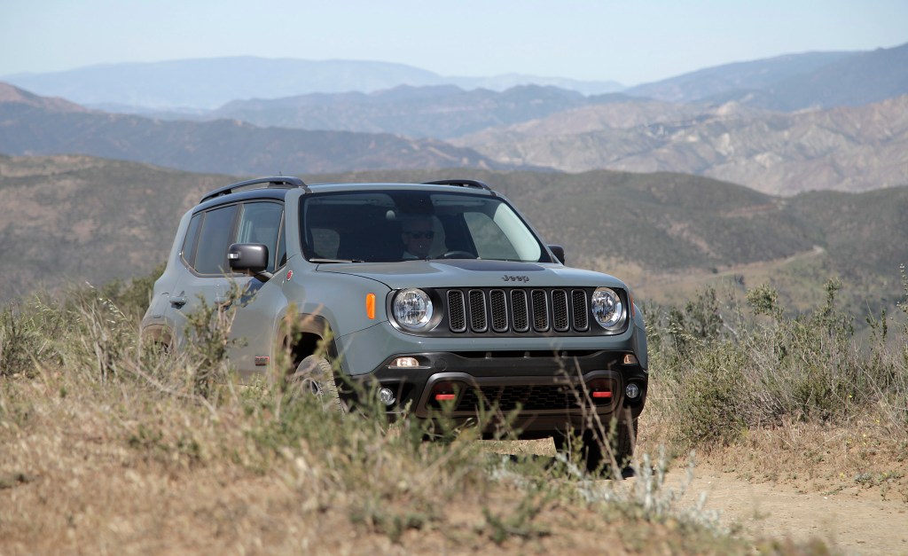 A Jeep Renegade Trailhawk drives down a dirt road