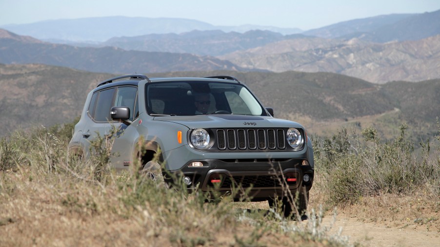 A Jeep Renegade Trailhawk drives down a dirt road