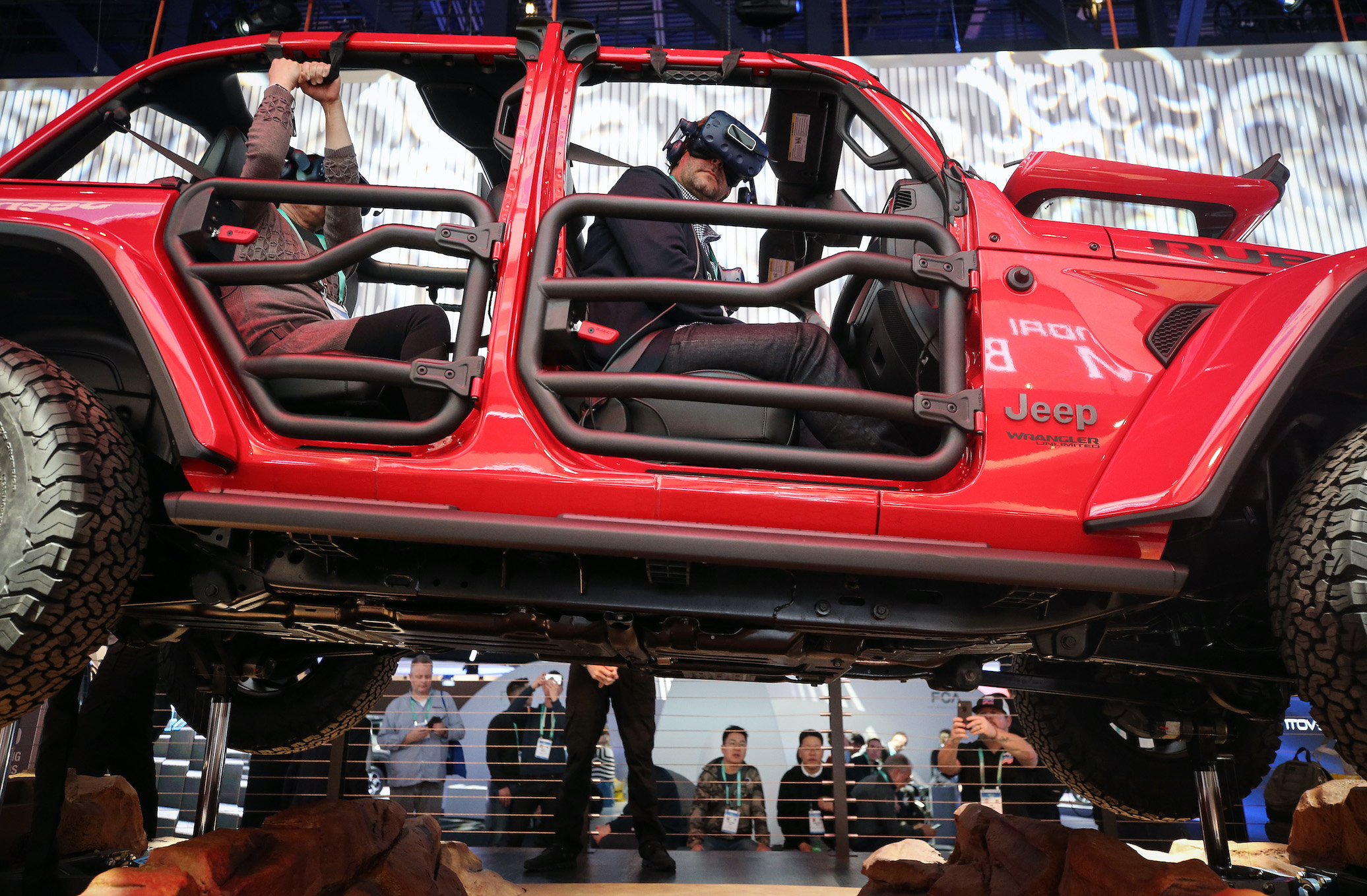 An attendee wears a virtual reality headset while riding in a show version of a 2020 Jeep Wrangler Unlimited 4xe plug-in hybrid electric vehicle
