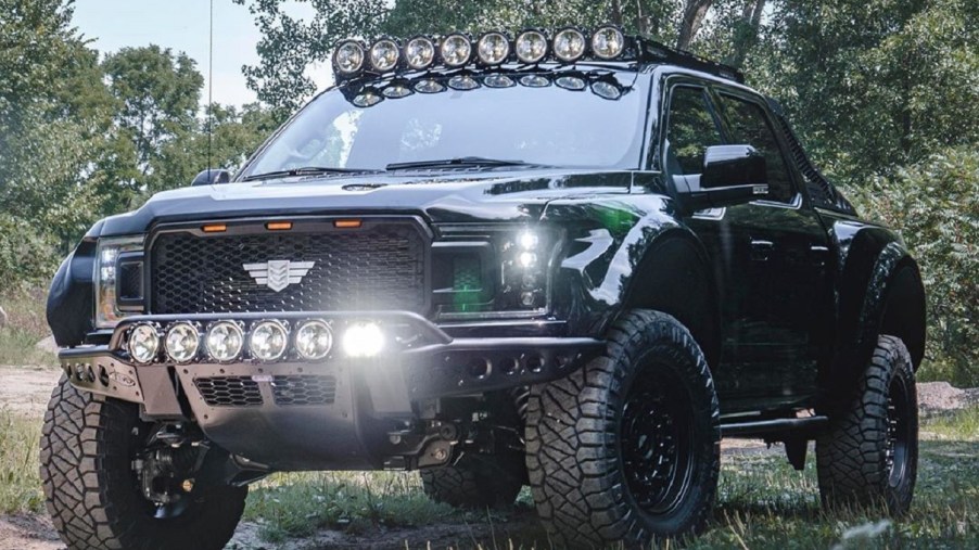 A black Mil-Spec supercharged Intrepid Ford F-150 in a forest