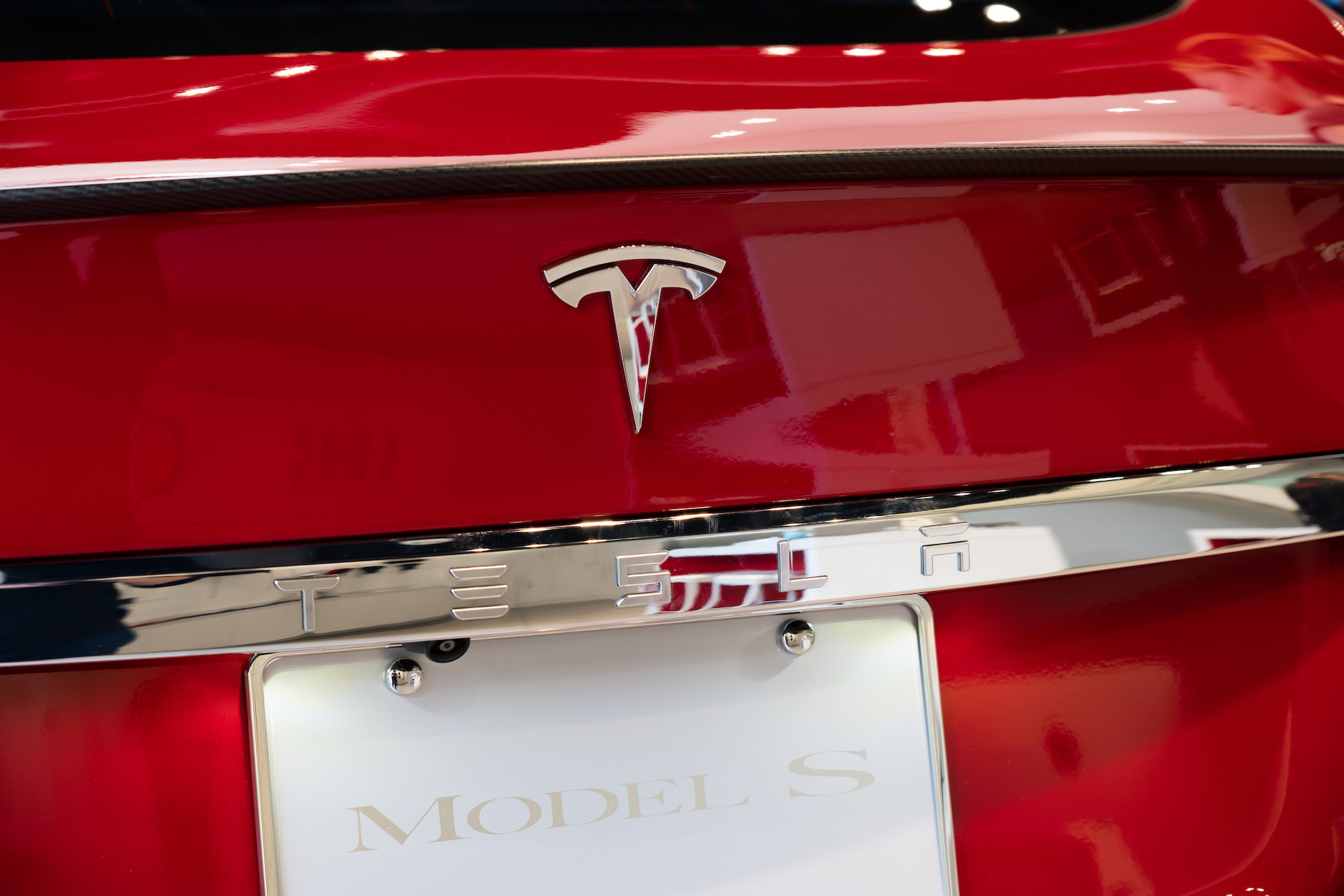 American electric vehicle and clean energy company Tesla logo seen on a Model S vehicle, now competing with the Lucid Air Dream..