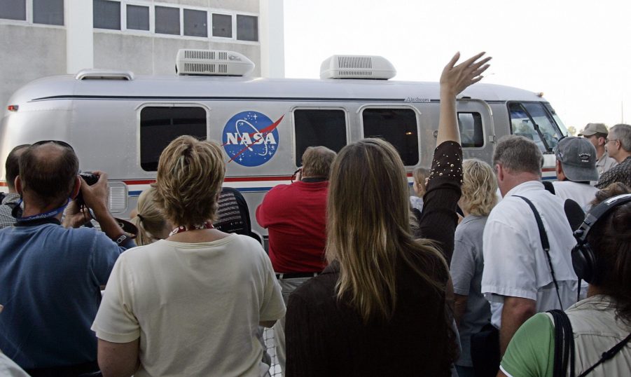 An employee of NASA waves to the crew of the Space Shuttle Atlantis as they leave