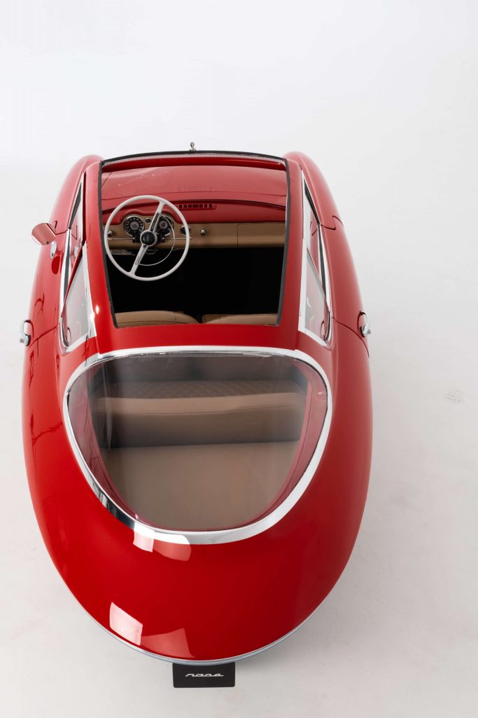 A view from behind a red Nobe GT100 electric autocycle shows the removed panoramic roof.