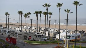 Campers parked in a lot next to the beach