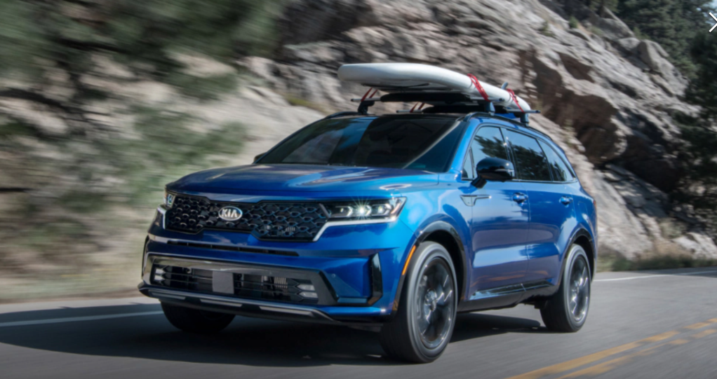 a blue 2021 Kia Sorento hybrid crossover SUV driving at speed in the mountains