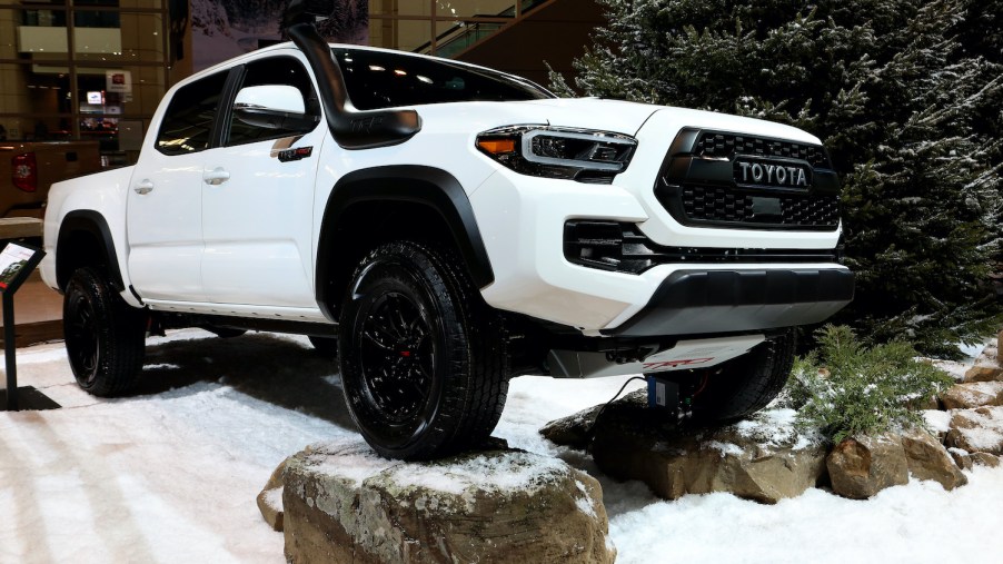 A white Toyota Tacoma displayed at an auto show.