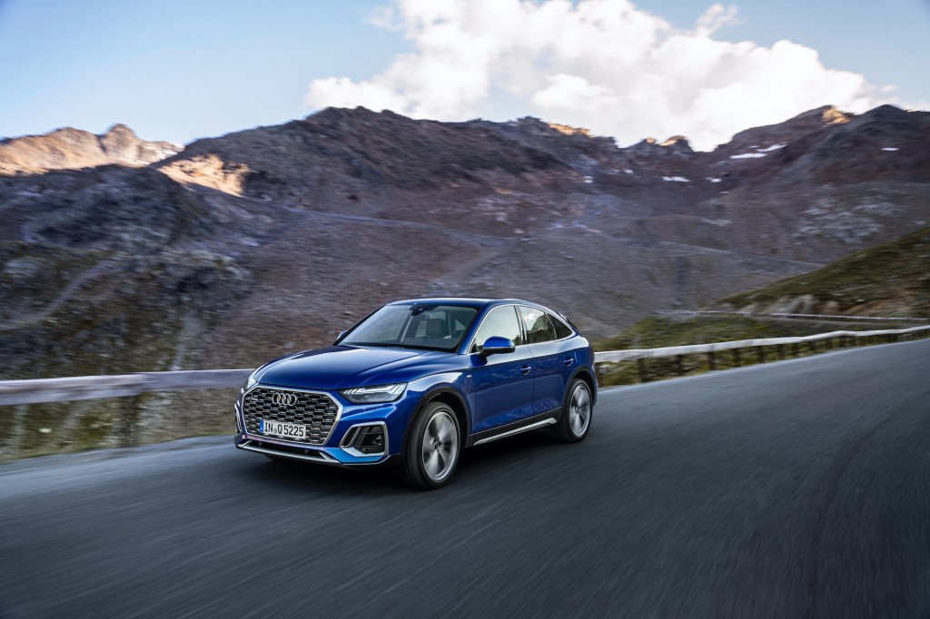 An electirc blue 2021 Audi Q5 Sportback driving on the countryside.